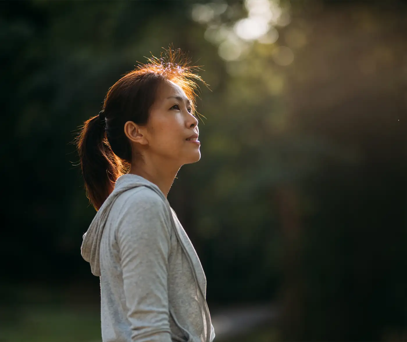 Woman in sunbeam in forest