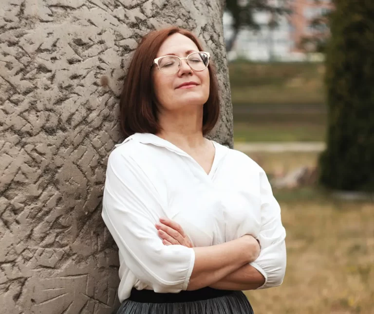 Woman leaning against a tree